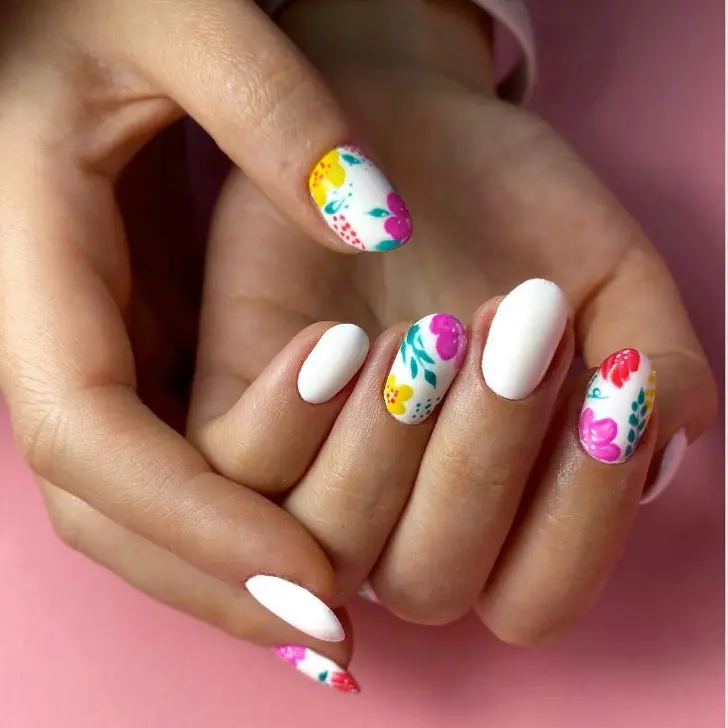 Белый маникюр с ярким цветочным принтом на ухоженных овальных ногтях