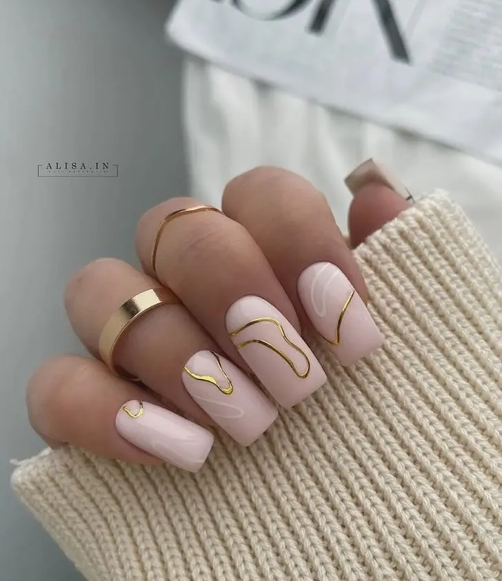 Бледно розовые ногти с золотыми и белыми кривыми линиями