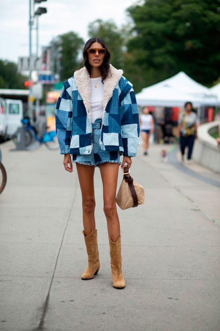 Девушка в джинсовых шортах, куртке и замшевых сапогах в ковбойском стиле