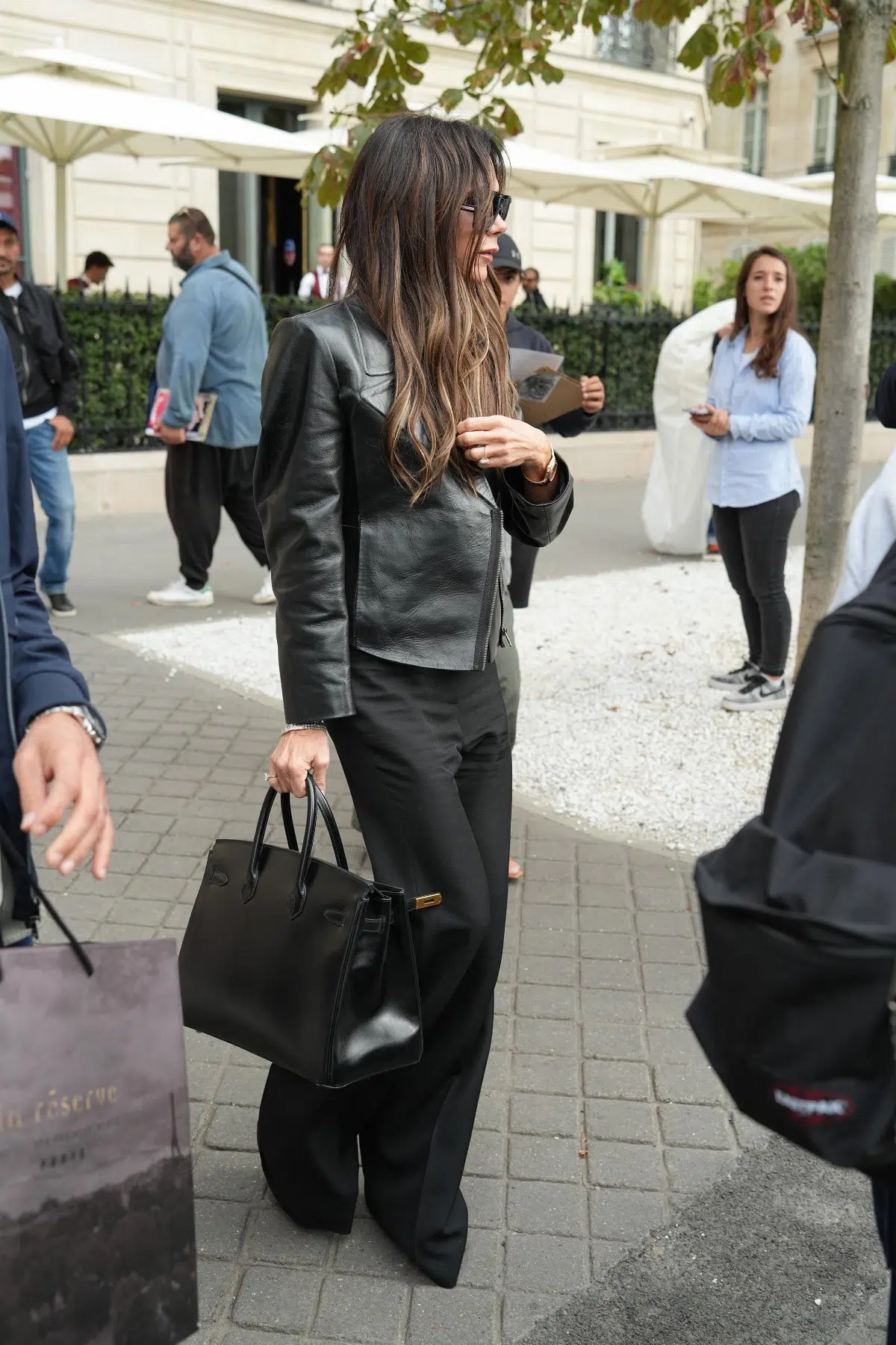 Виктория Бекхэм в кожаной куртке, брюках в пол и обуви на платформе