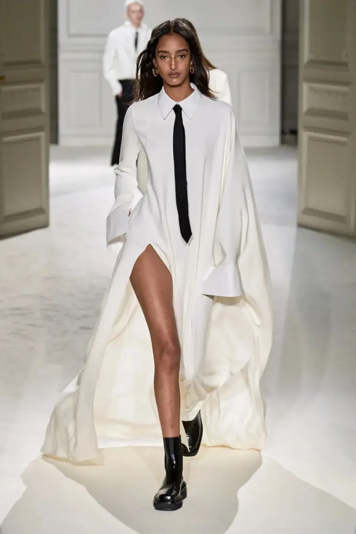 Модель в белом платье оверсайз и классической рубашке с галстуком от valentino