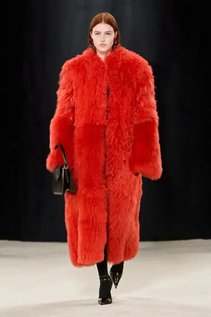 Модель в красном меховом пальто оверсайз от Ferragamo