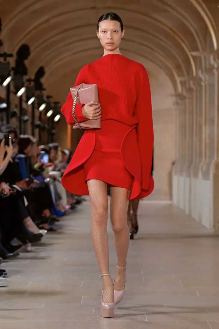 Модель в красном мини платье с длинными рукавами и туфлях на платформе от victoria beckham