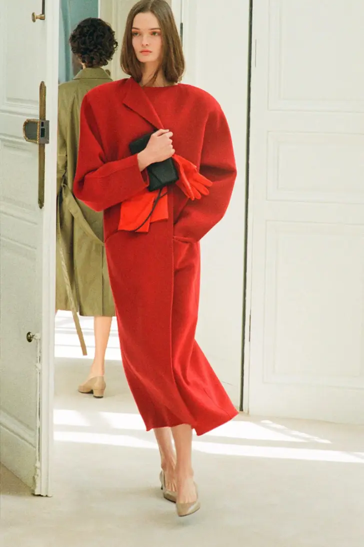 Модель в красном пальто без воротника и объемными плечами от the row