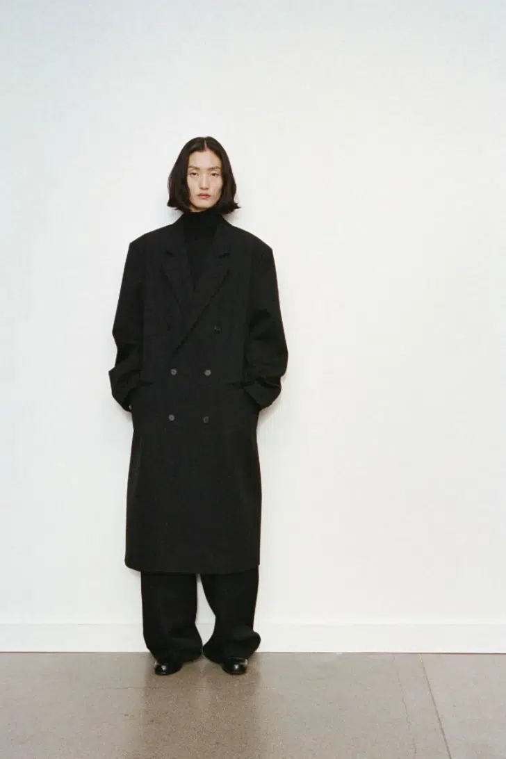 Модель в минималистичном черном пальто оверсайз от The Row