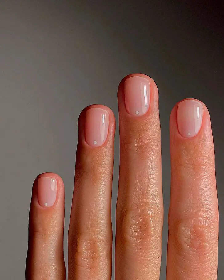 Натуральный минималистичный маникюр с белой точкой у основания на коротких ногтях