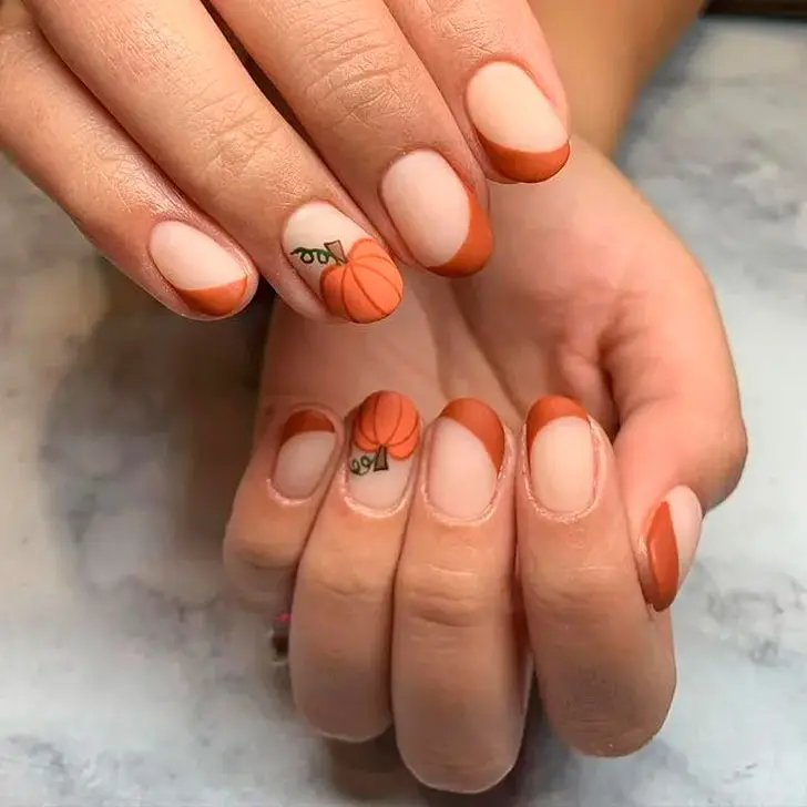 Оранжевый диагональный френч с принтом тыквы на коротких овальных ногтях