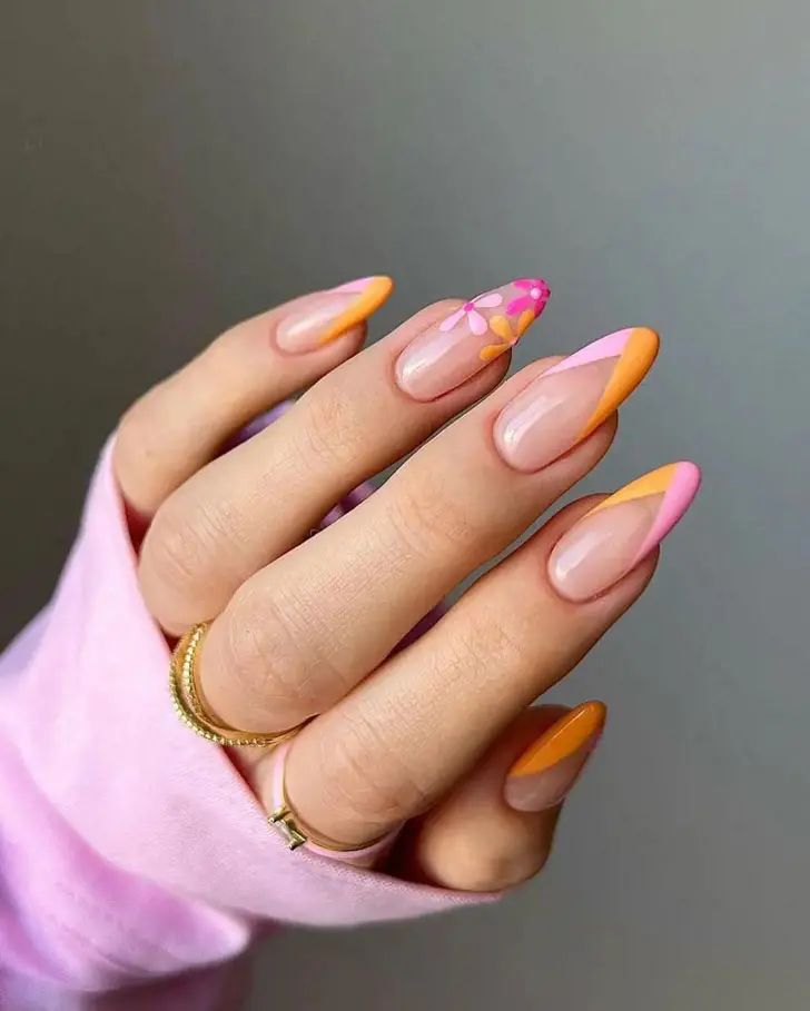 Розово-оранжевый треугольный френч с цветами на длинных миндальных ногтях