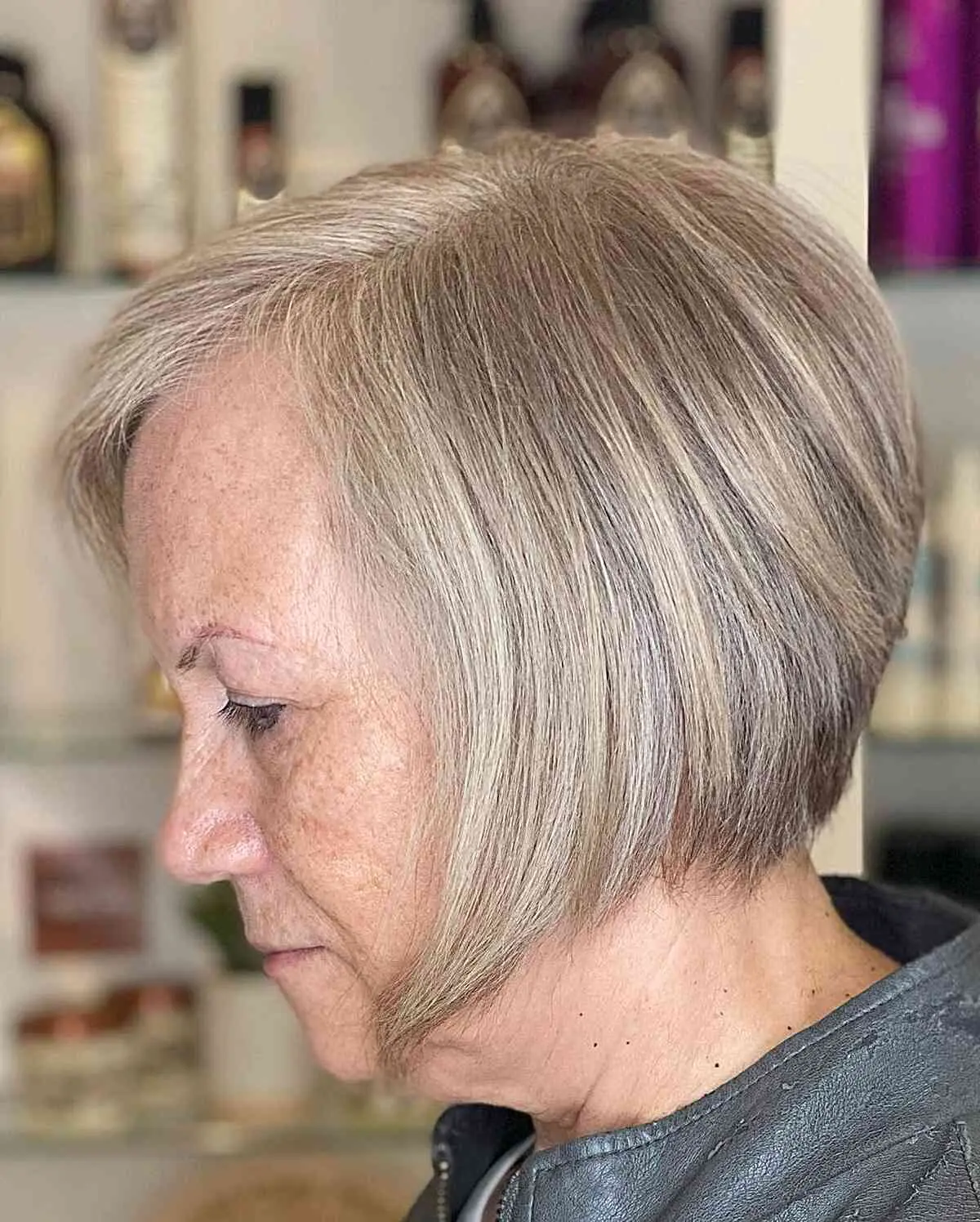Женщина с короткой стрижкой боб с боковым пробором на светлых тонких волосах