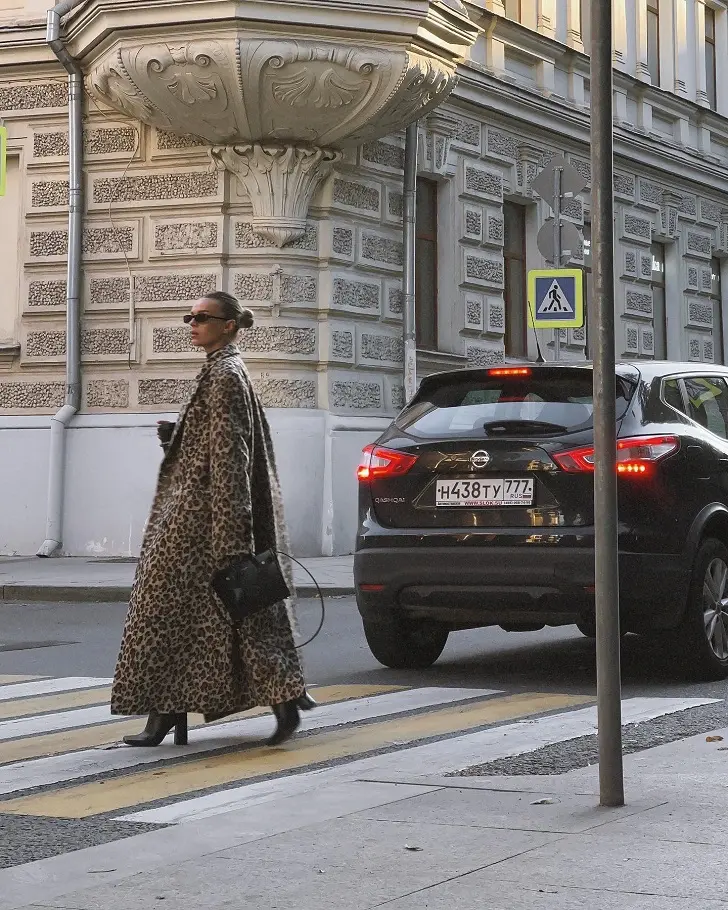 Девушка в длинном леопардовом пальто и черных ботильонах