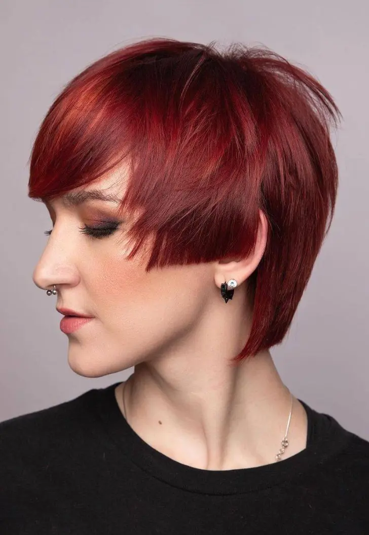 Девушка с прямой короткой стрижкой с боковой челкой на волосах с красным оттенком