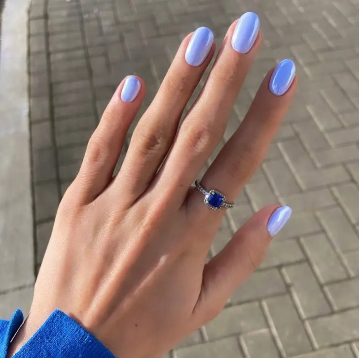 Голубой маникюр с перламутровым блеском на ухоженных овальных ногтях