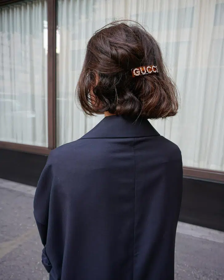 Марта Сайган с полусобранной стрижкой боб с модной заколкой на густых волосах