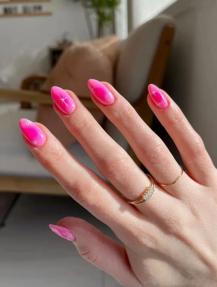 Розовый маникюр омбре со звездами на овальных ногтях