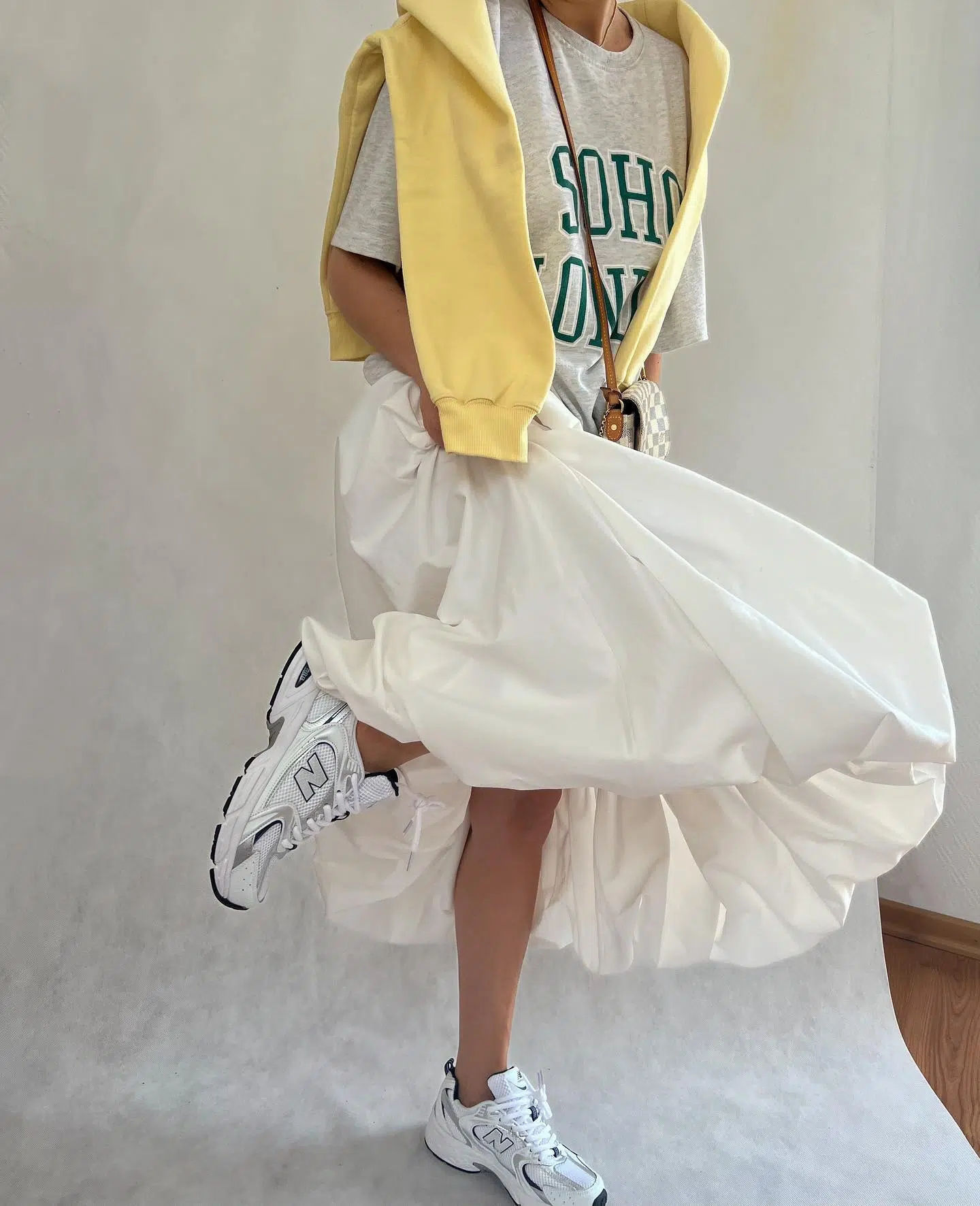 Девушка в молочной юбке-баллон, футболке и модных кроссовках