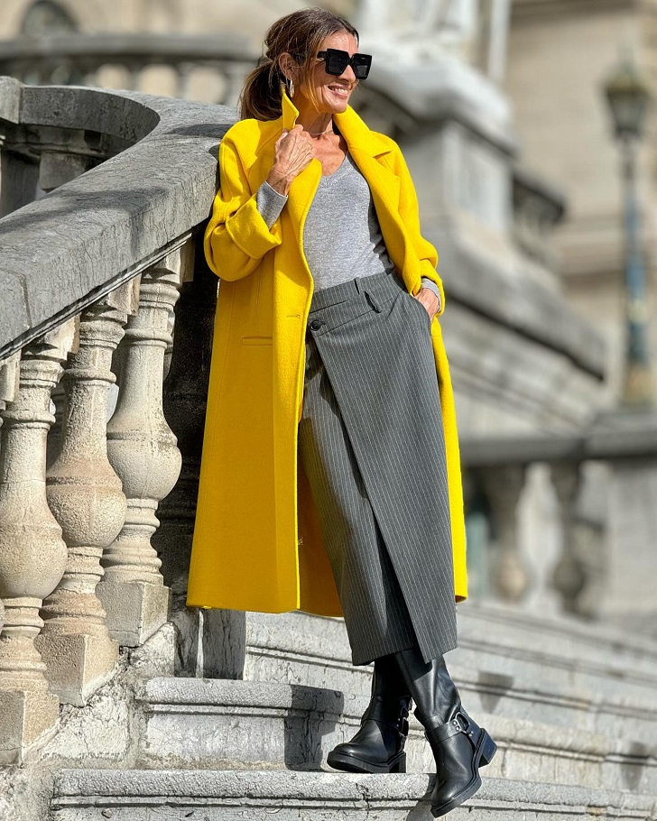 Женщина в желтом пальто с серым аутфитом и грубыми ботинками