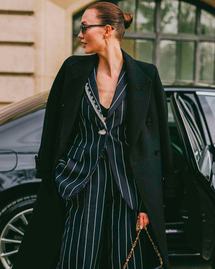 Девушка в черном брючном костюме в линию и классическом пальто