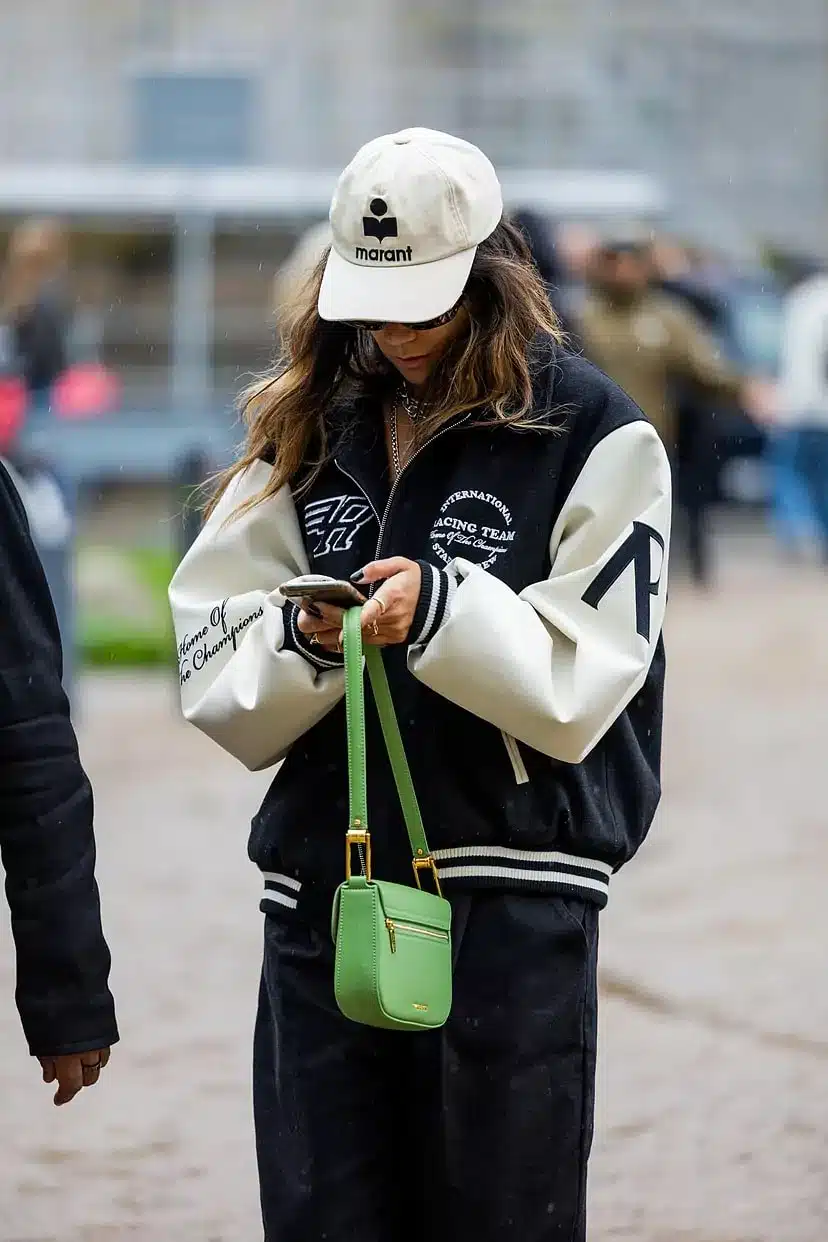 Девушка в куртке бомбер с надписями, свободных брюках и светлой кепке