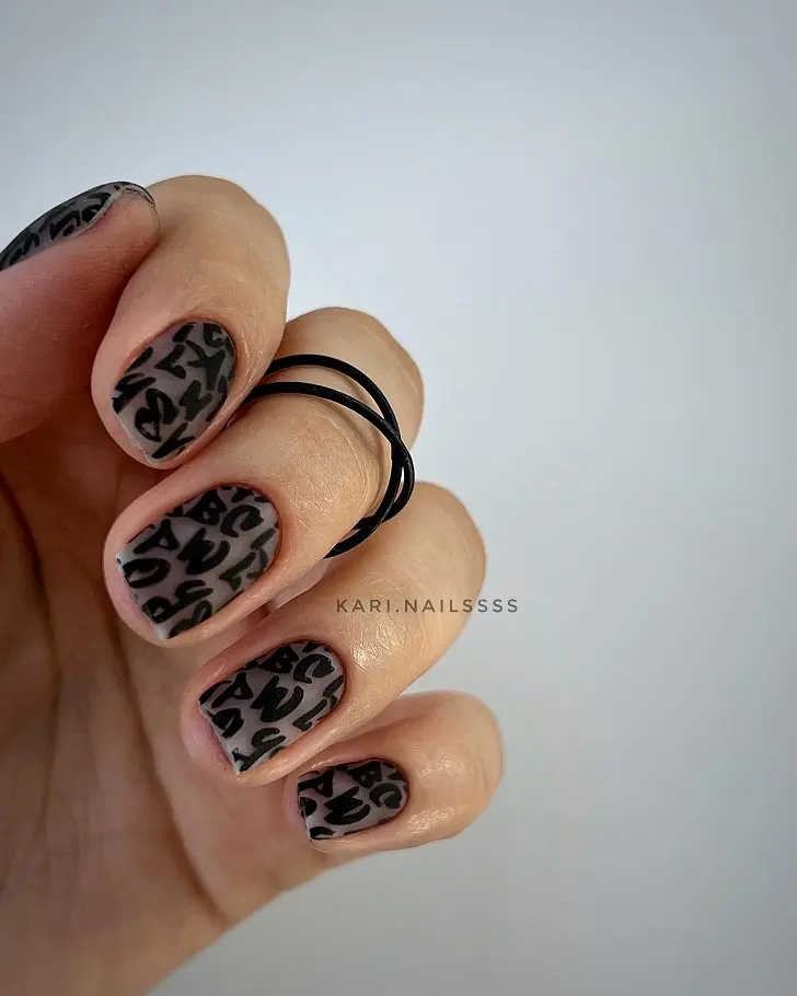 Короткие ногти с черными буквами и покрытием с эффектом бархата