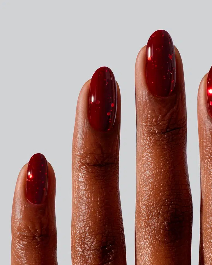 Красный маникюр с блестками на овальных ногтях