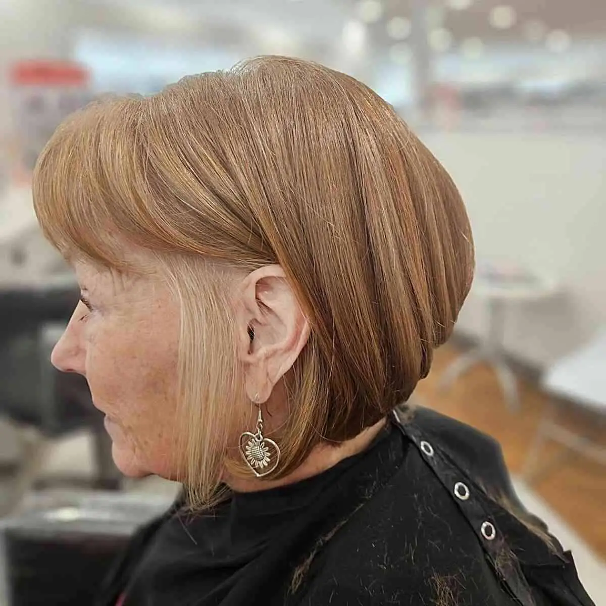 Женщина с объемной стрижкой боб с челкой на светлых волосах