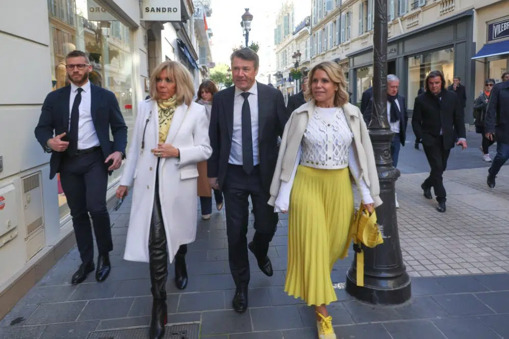 Брижит Макрон в пальто и кожаных брюках идет по улицам Парижа