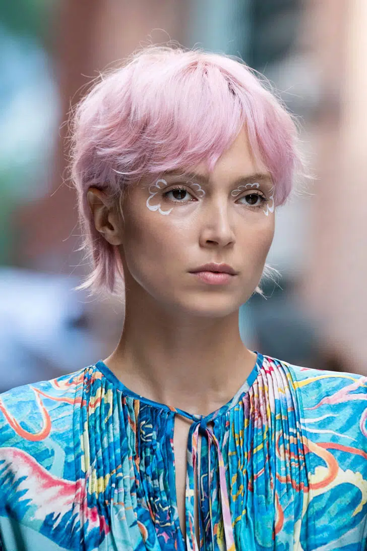 Девушка со стрижкой пикси с открытой челкой на розовых волосах