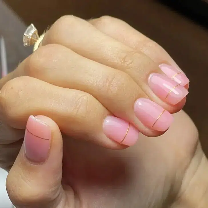 Глянцевый розовый маникюр с золотой линией на коротких ногтях