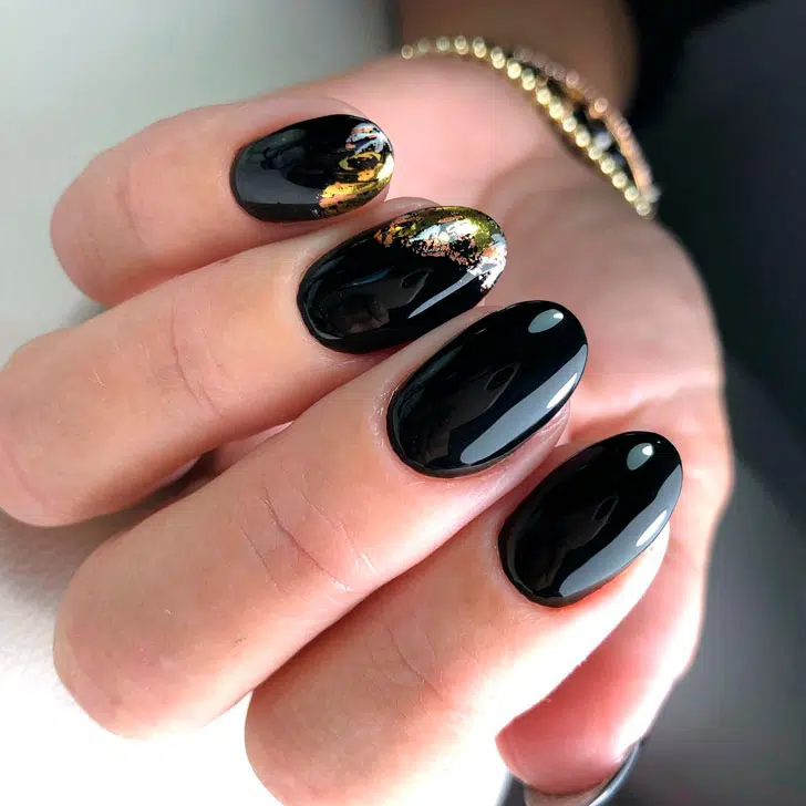 Изысканный черный маникюр с золотом на овальных ногтях
