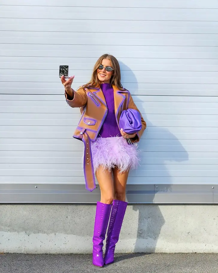Фиолетовые сапоги с мини юбкой из перьев и кожаной курткой
