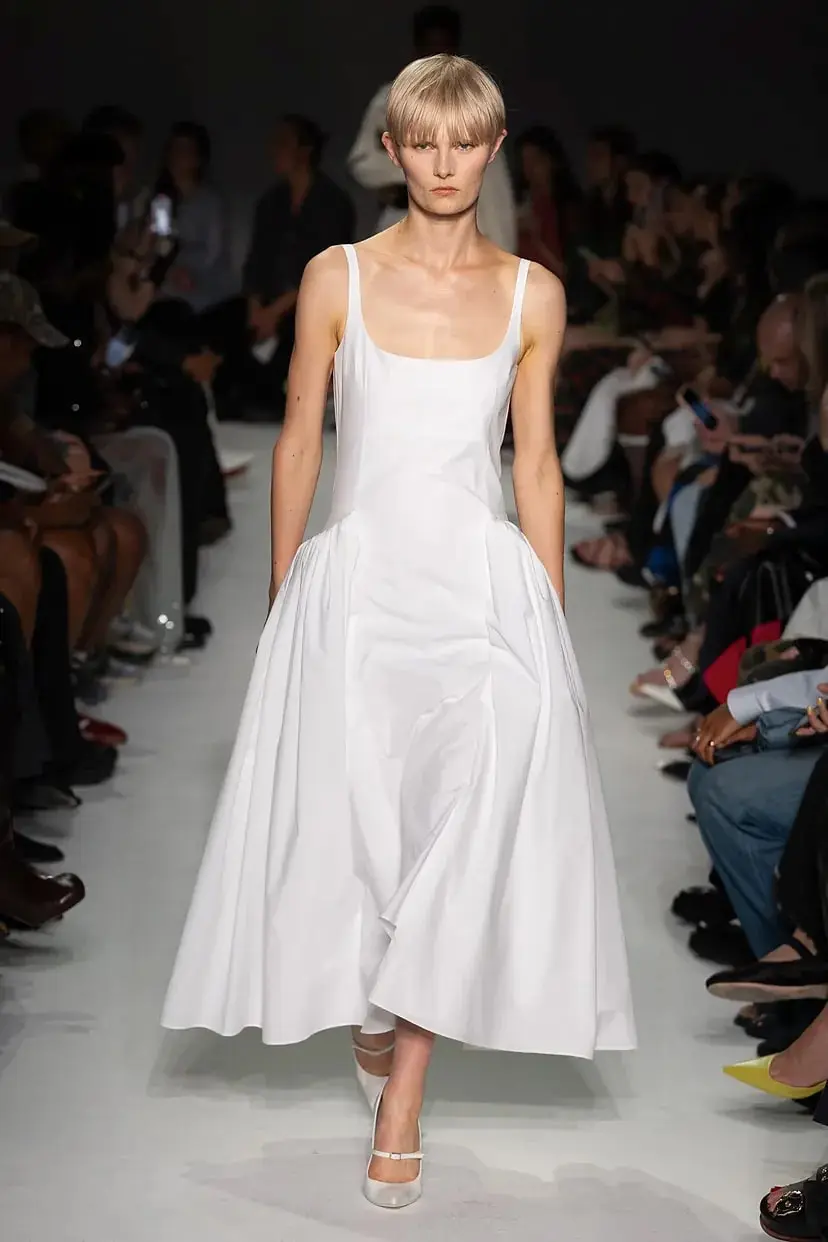 Модель в белом платье миди с пышной юбкой от 16Arlington