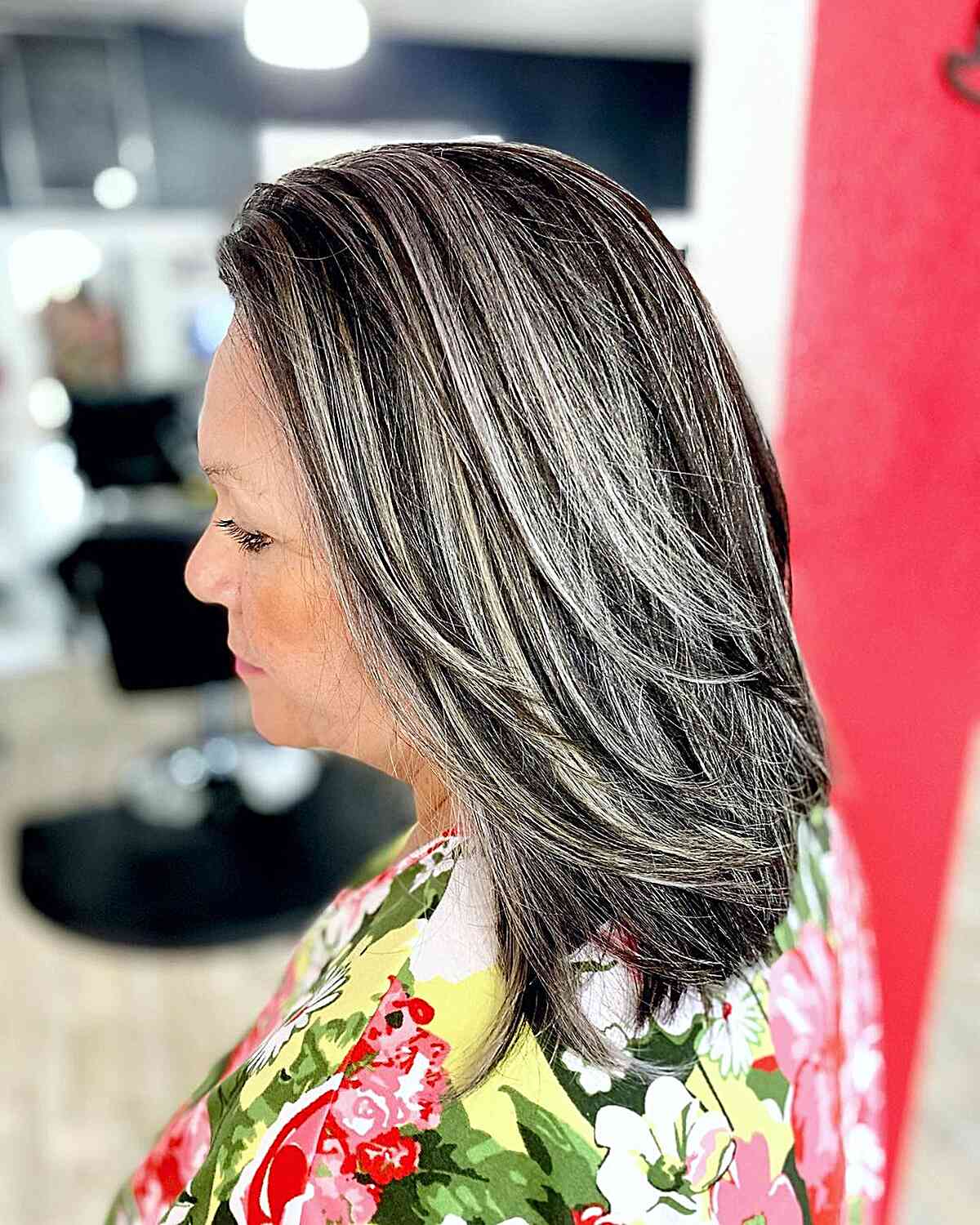 Женщина со светлыми прядями на темных волосах средней длины