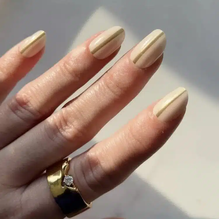 Бежевый маникюр с золотой линией по центру на овальных ногтях