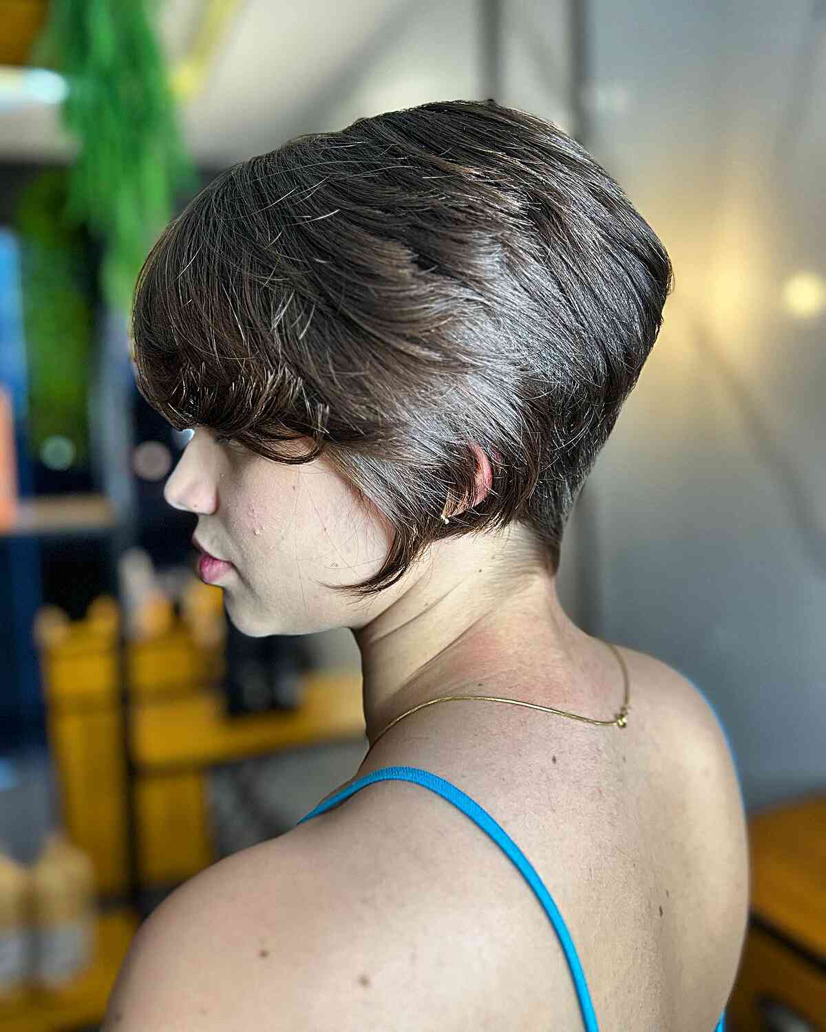 Девушка с объемной многослойной стрижкой на ухоженных блестящих волосах