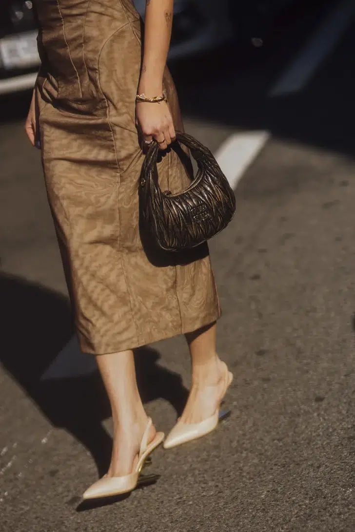 Девушка в облегающем платье миди и туфлях с открытой пяткой