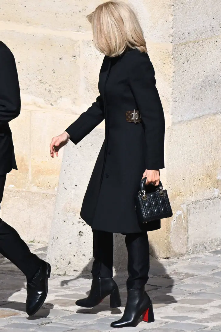Брижит Макрон с легендарной сумочкой Dior и стильном черном пальто