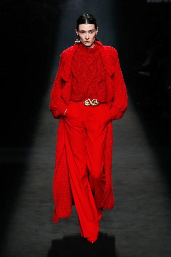 Модель красных брюках, свитере и пальто