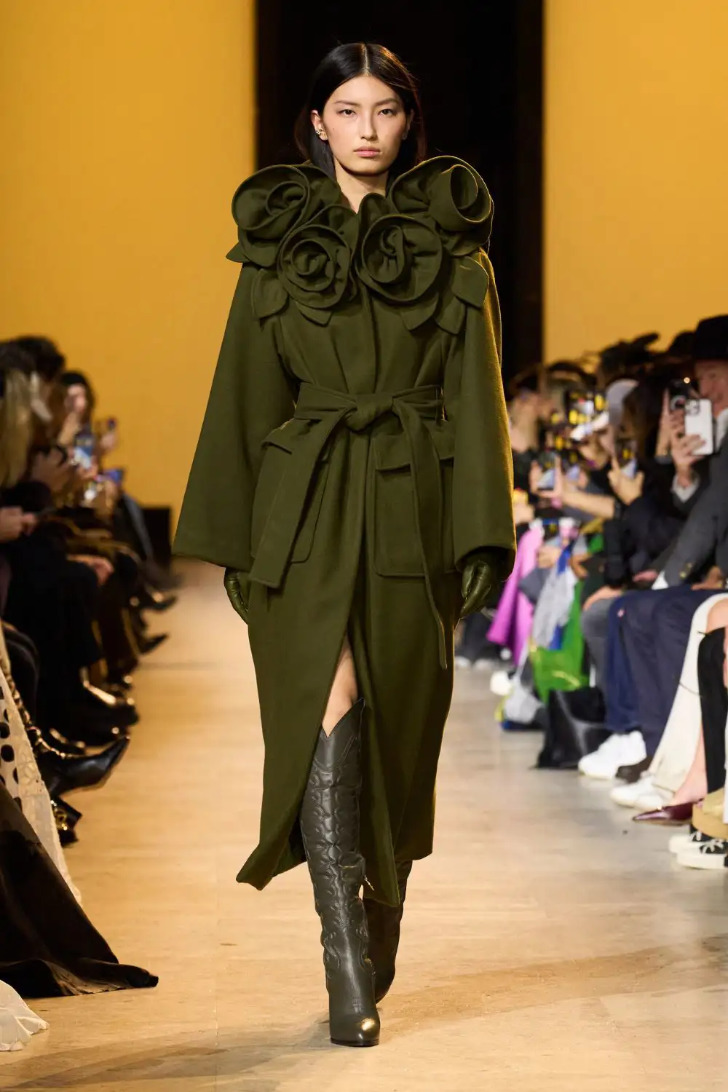 Модель в темно оливковом пальто с объемными цветами