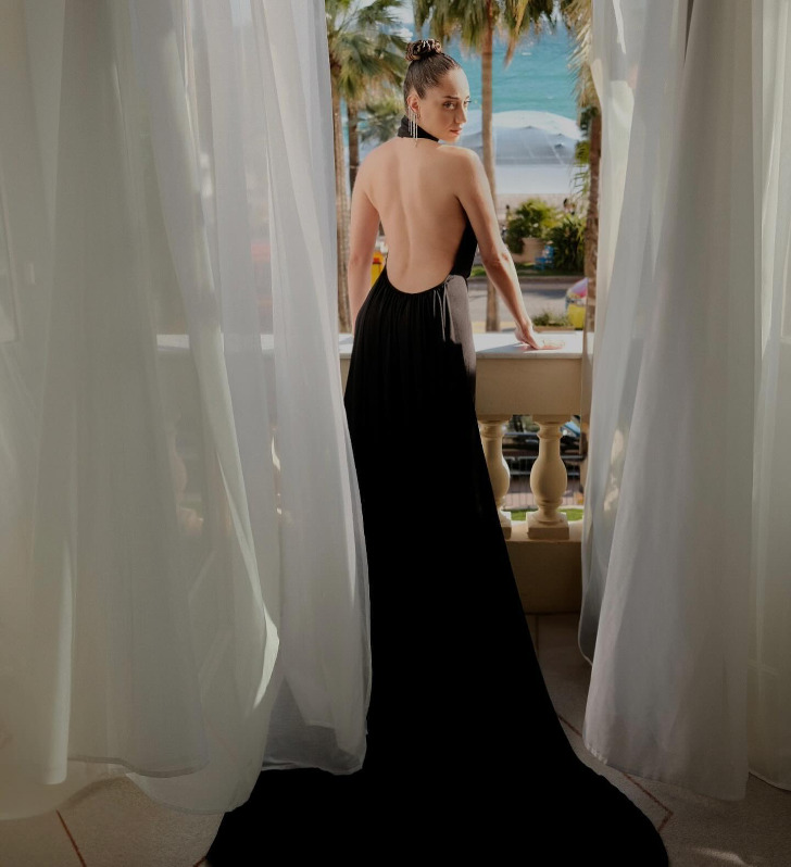 Озге Озаджарв длинном черном платье с открытой спиной